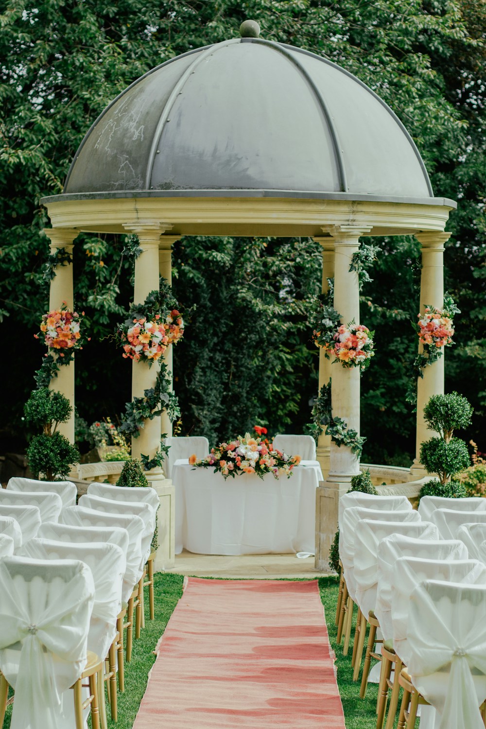 An intimate garden ceremony with a flower-adorned pavilion