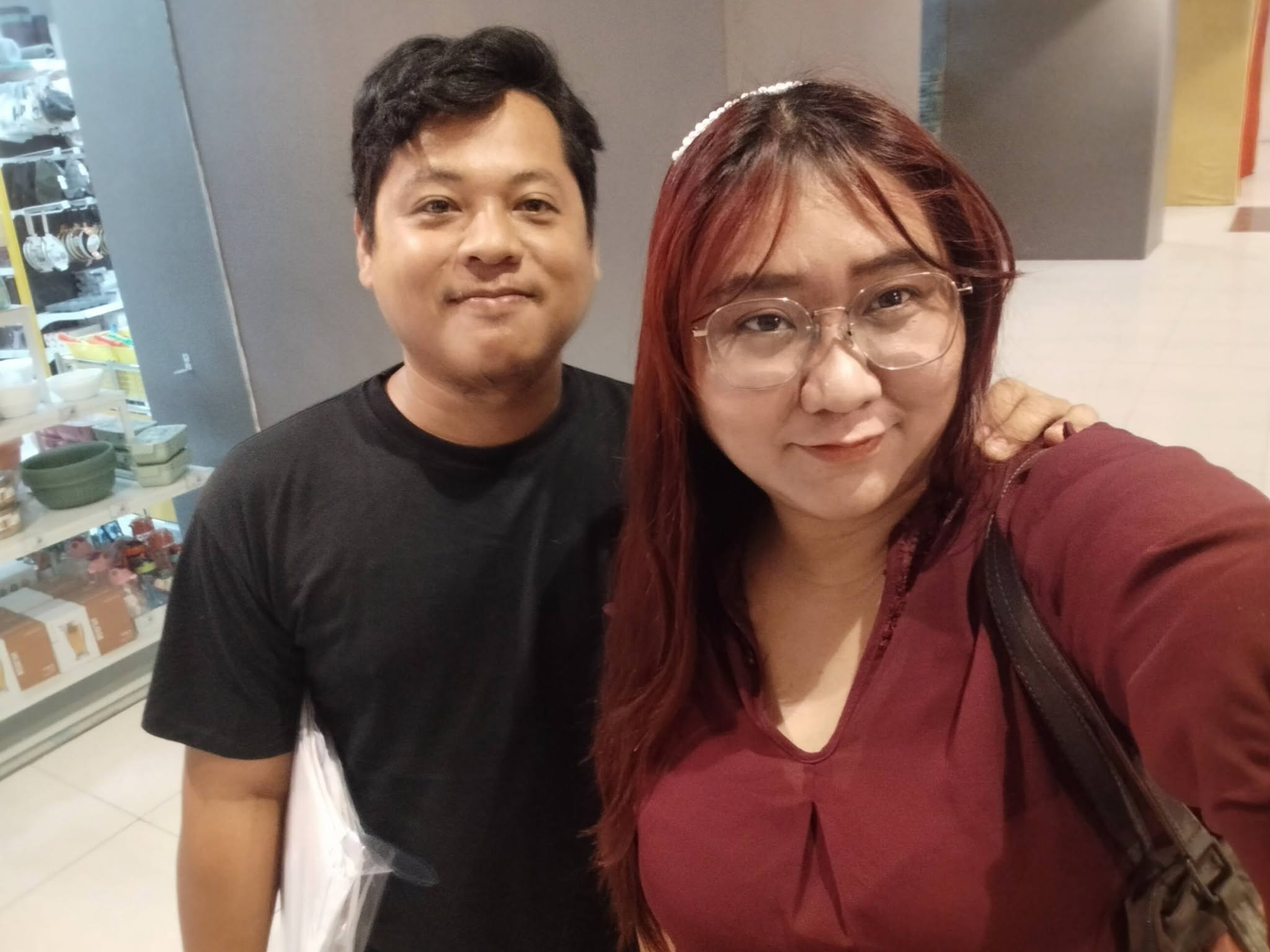 The couple standing close together for a selfie in burgundy and black